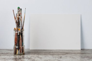 Bir cam fırça boya, kavanoz. Açık mavi arka planı üzerinde. Kopya alanı ile