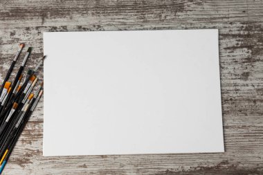 ile sanatsal boya fırçaları kümesini boyalı, eski ahşap arka plan üzerinde sonraki tuval. Kopya alanı ile.