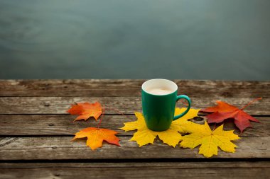 Eski ahşap arka plan üzerinde kahve kapuçino ve sonbahar yaprakları.