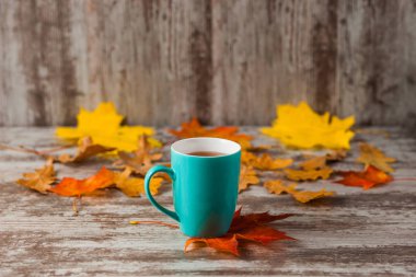 Mavi fincan çay. Ahşap eski antika arka plan. Sonbahar yaprakları. Sarı kırmızı.