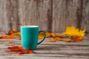 Mavi fincan çay. Ahşap eski antika arka plan. Sonbahar yaprakları. Sarı kırmızı.