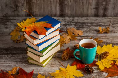 Autumn.A bardak çay. Kitap renkli. Sarı kırmızı yapraklar