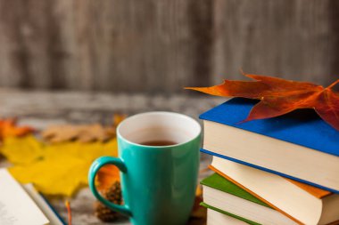 Sonbahar. Açık bir kitap. Çay, kahve, kakao. Sarı kırmızı yapraklar. Ahşap arka plan