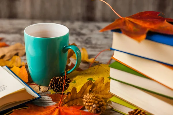 Autumn. Book. Cup of tea. Yellow red leaves. Wooden background