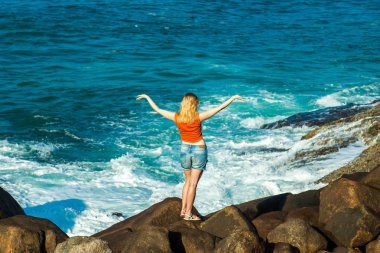 Kız okyanus plaj üzerinde elleriyle ayağa kalkar