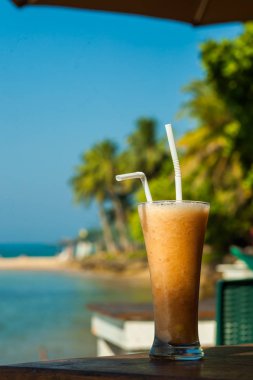 deniz dikey arka plan üzerinde taze tropikal meyve suyu