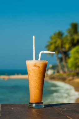 deniz dikey arka plan üzerinde taze tropikal meyve suyu