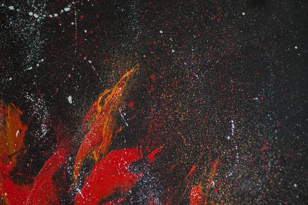 Red smears of orange paint on a black background