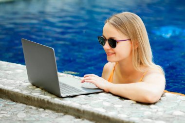 kız bir dizüstü bilgisayarda çalışan havuzu