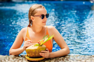 Güneş gözlüğü ile havuz içinde Hindistan cevizi ile kız