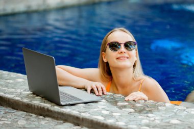 havuzun bir dizüstü bilgisayarda çalışan kız