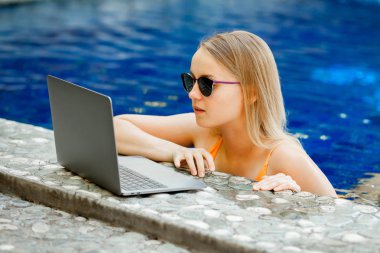 havuzun bir dizüstü bilgisayarda çalışan kız