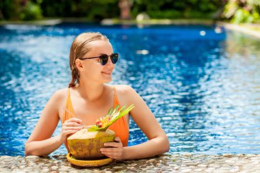 Bir Hindistan cevizi içme havuzunda rahatlatıcı kızdır