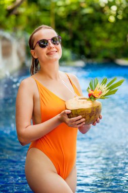 Dikey havuzda bir Hindistan cevizi içme kız