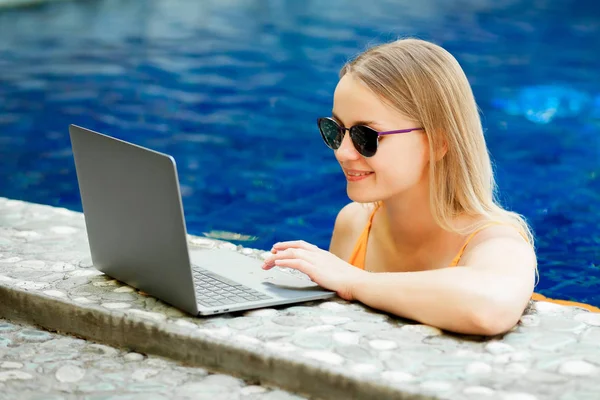 kız bir dizüstü bilgisayarda çalışan havuzu