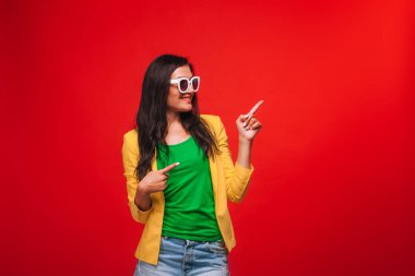 Sarı ceket kırmızı arka plan kız kopya sp kadar parmaklarını gösterir