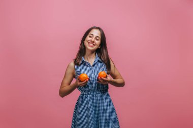 Kız pembe bir arka plan üzerinde turuncu ile göğüslerini örttü