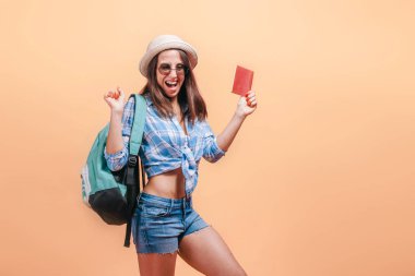Sarı bir arka plan üzerinde sırt çantası ile kız turist gösterir 