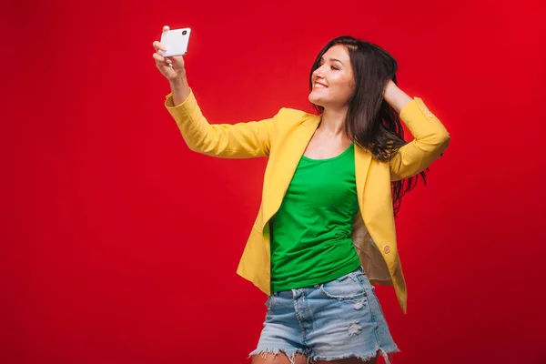 A menina tira uma selfie em um telefone celular — Fotografia de Stock