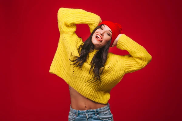 Menina em suéter amarelo e chapéu no fundo vermelho — Fotografia de Stock