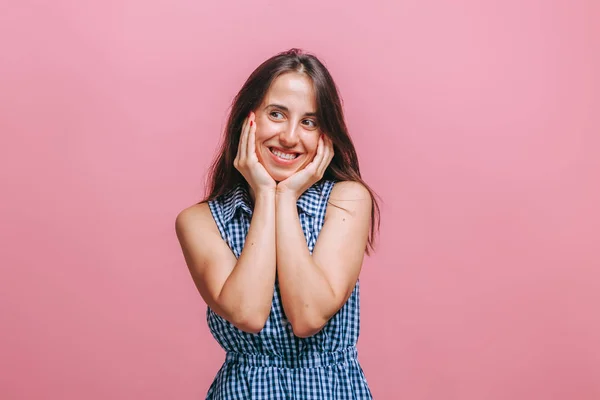 Uma menina em um vestido azul fica em um fundo rosa e sorri — Fotografia de Stock