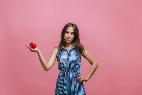 Dziewczyna trzyma Czerwone jabłko na różowym tle — Zdjęcie stockowe