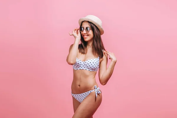 Menina em óculos de sol maiô e chapéu no fundo rosa . — Fotografia de Stock