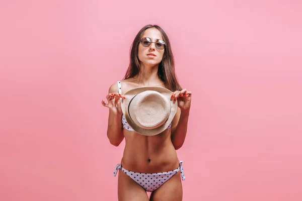분홍색 배경에 수영복 선글라스와 모자를 쓴 소녀. — 스톡 사진