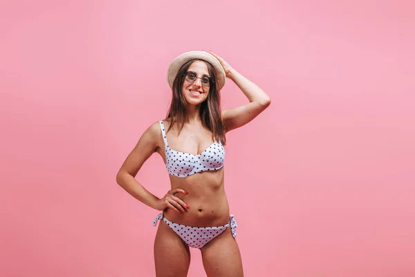 Dziewczyna w strój kąpielowy okulary przeciwsłoneczne i kapelusz na różowym tle. — Zdjęcie stockowe