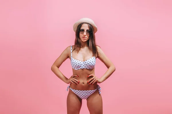 Ragazza in costume da bagno occhiali da sole e cappello su sfondo rosa . — Foto Stock