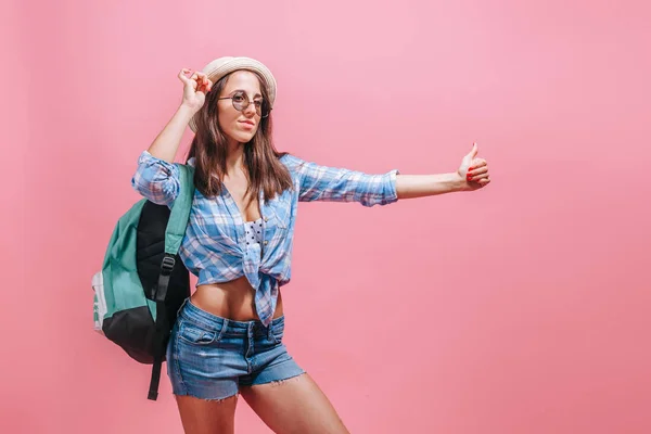 Menina caminhante pega um passeio em um fundo rosa — Fotografia de Stock