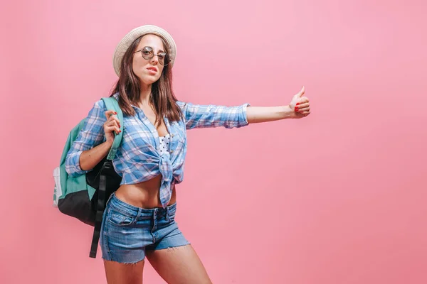 Menina caminhante pega um passeio em um fundo rosa — Fotografia de Stock