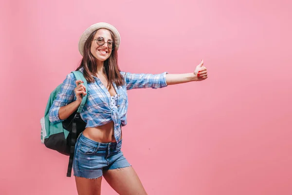 Menina caminhante pega um passeio em um fundo rosa — Fotografia de Stock