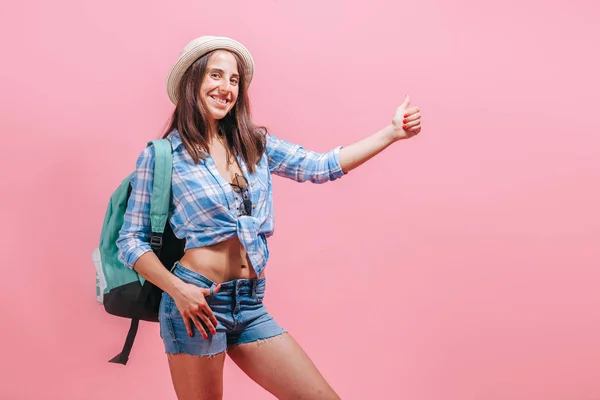 Menina caminhante pega um passeio em um fundo rosa — Fotografia de Stock