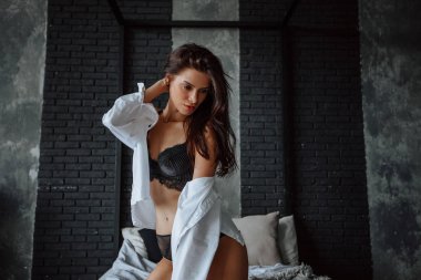 Siyah iç çamaşırı seksi esmer kız yatakta diz çöker