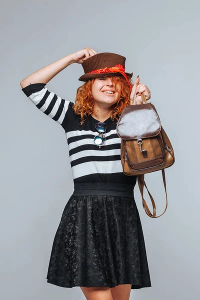 Chica turista cabeza roja con mochila sobre fondo gris —  Fotos de Stock