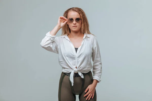 Chica de camisa blanca y gafas redondas sobre fondo gris — Foto de Stock