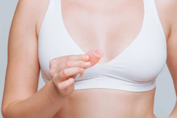 Chica sosteniendo copa menstrual sobre fondo gris claro — Foto de Stock