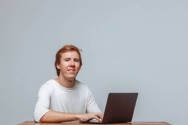 Bir la için hafif bir arka plan üzerinde gülümseyen kızıl saçlı adam programcı