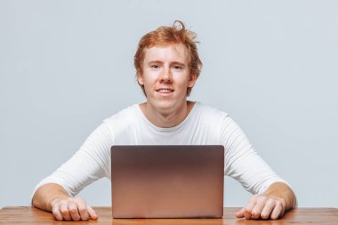 Bir la için hafif bir arka plan üzerinde gülümseyen kızıl saçlı adam programcı