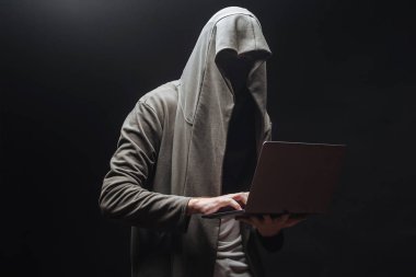 Gece kapüşonlu dizüstü bilgisayar ile Suçlu