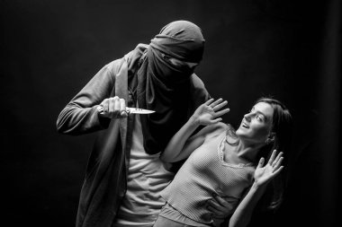 Adam bir kızı bıçakla bıçaklamak istiyor. siyah-beyaz