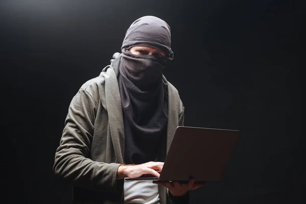 Terrorysta z laptopem przygotowuje przestępczość w nocy — Zdjęcie stockowe