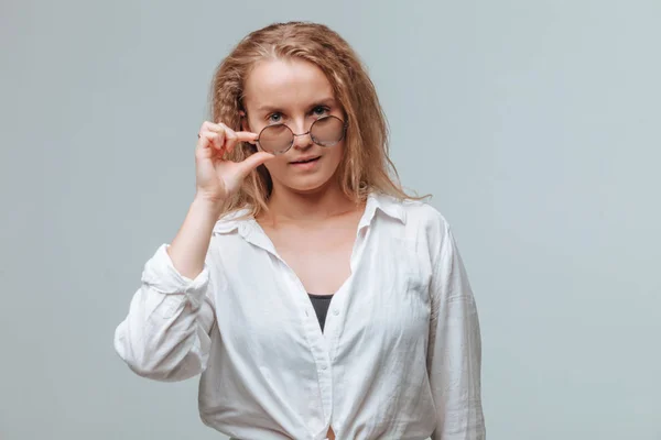 Chica de camisa blanca y gafas redondas sobre fondo gris —  Fotos de Stock