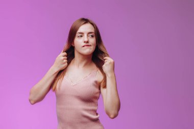 Kız pembe arka planda dudağını ısırıyor