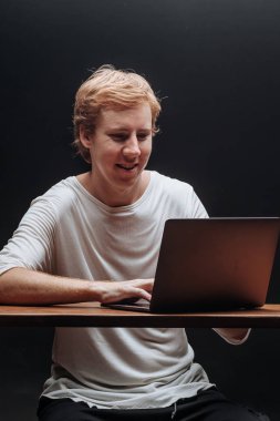 bir lapto ile siyah bir arka plan üzerinde beyaz bir t-shirt programcı