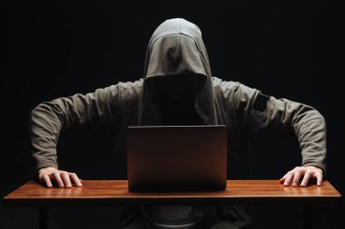 Siyah arka planda kapüşonlu dizüstü bilgisayar ile Ceza