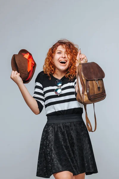 Cabeça vermelha menina turística com mochila no fundo cinza — Fotografia de Stock