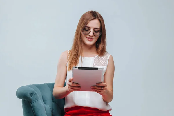 Mädchen arbeitet am Tablet sie ist in roter Hose, Brille und Sittin — Stockfoto