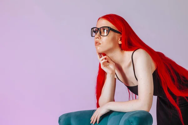 Retrato de una chica con el pelo largo rojo usando gafas en un rosa —  Fotos de Stock